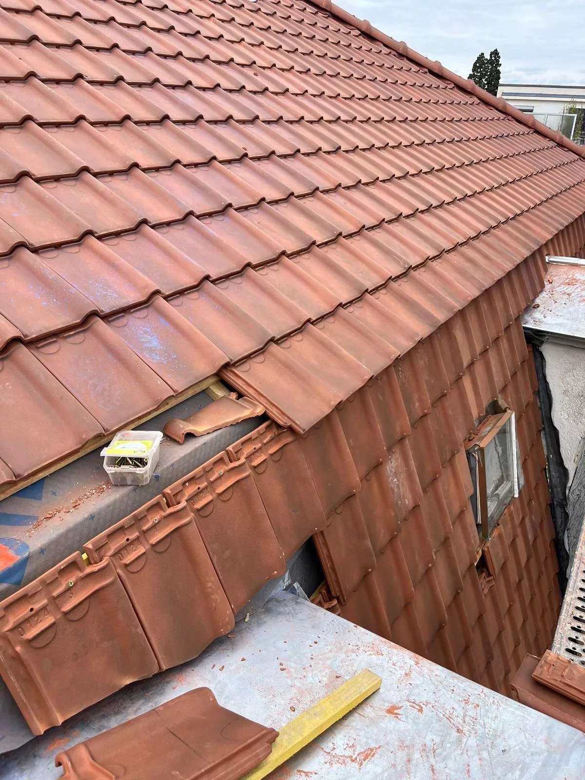Pose de tuiles sur une toiture par un couvreur à Montreux